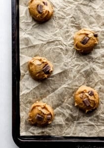 Cookie dough added to parchment lined baking sheet.