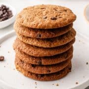Close up side view of stack of cookies on a white plate on pin with text overlay.