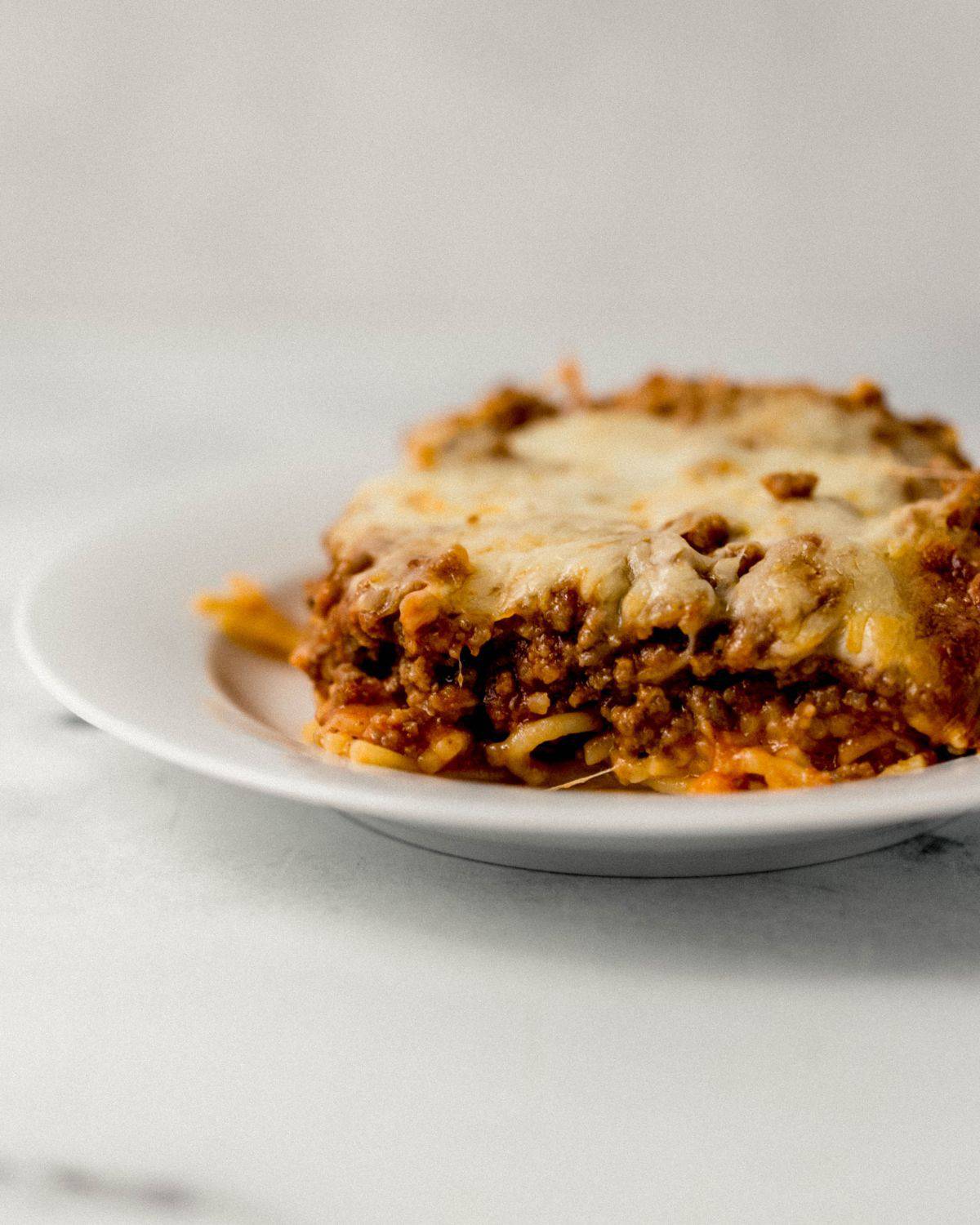 Close up side view of plate with serving of spaghetti on it. 