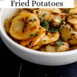 Close up front view of potatoes in white bowl on black tile surface pin with text overlay.
