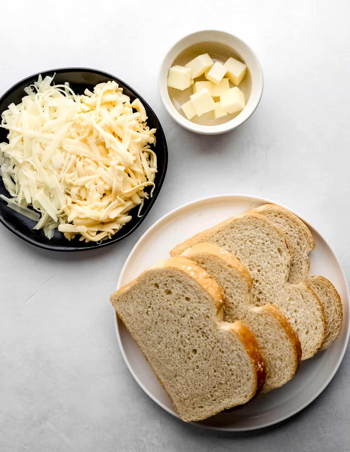 Overhead view of ingredients needed to make sandwich in separate plates.