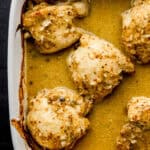Overhead view of chicken in square white baking dish.