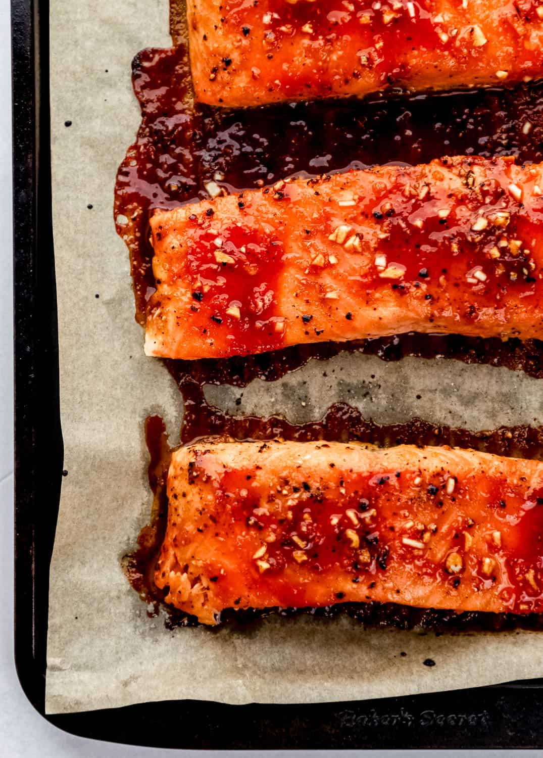 Baked salmon on parchment lined baking sheet. 