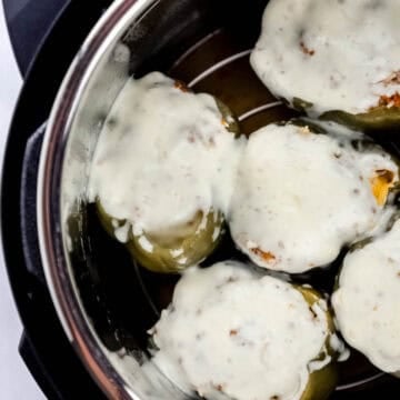 Overhead view of cooked peppers topped with melted cheese in instant pot.