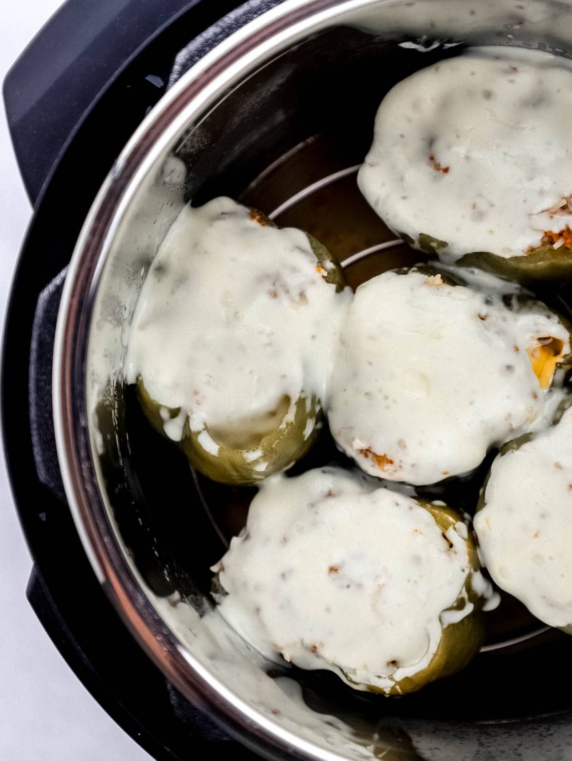 Overhead view of stuffed peppers topped with melted cheese in the instant pot 