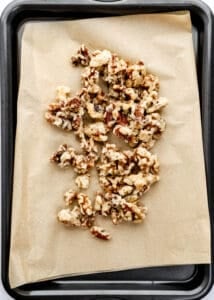 Candied walnuts on parchment lined sheet pan.