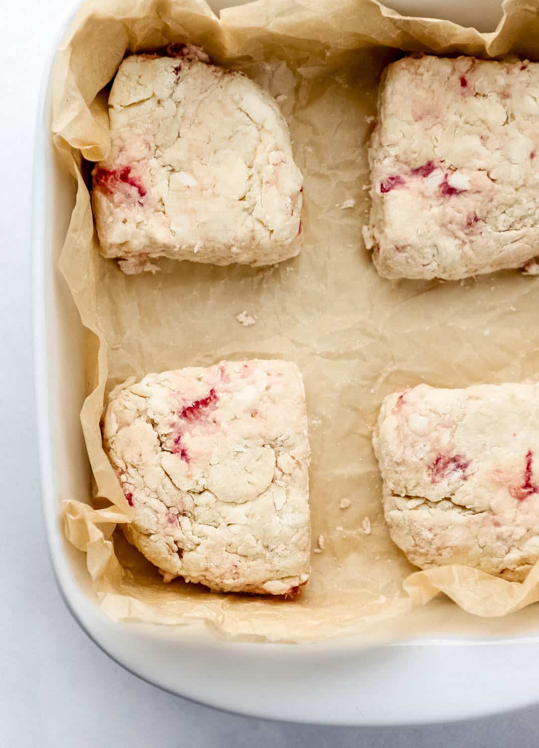 Cut biscuits added to parchment lined baking dish. 