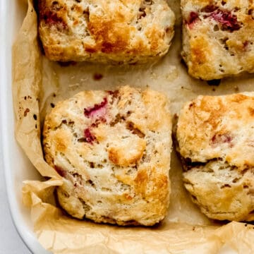 Overhead view of strawberry biscuits in parchment lined baking dish.