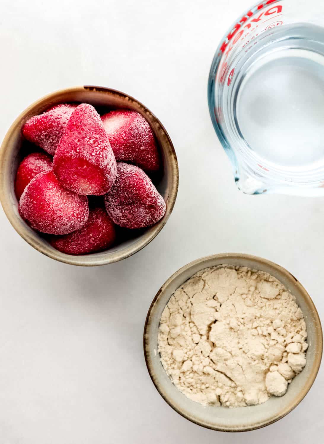 Overhead view of three ingredients needed to make smoothie in separate containers. 