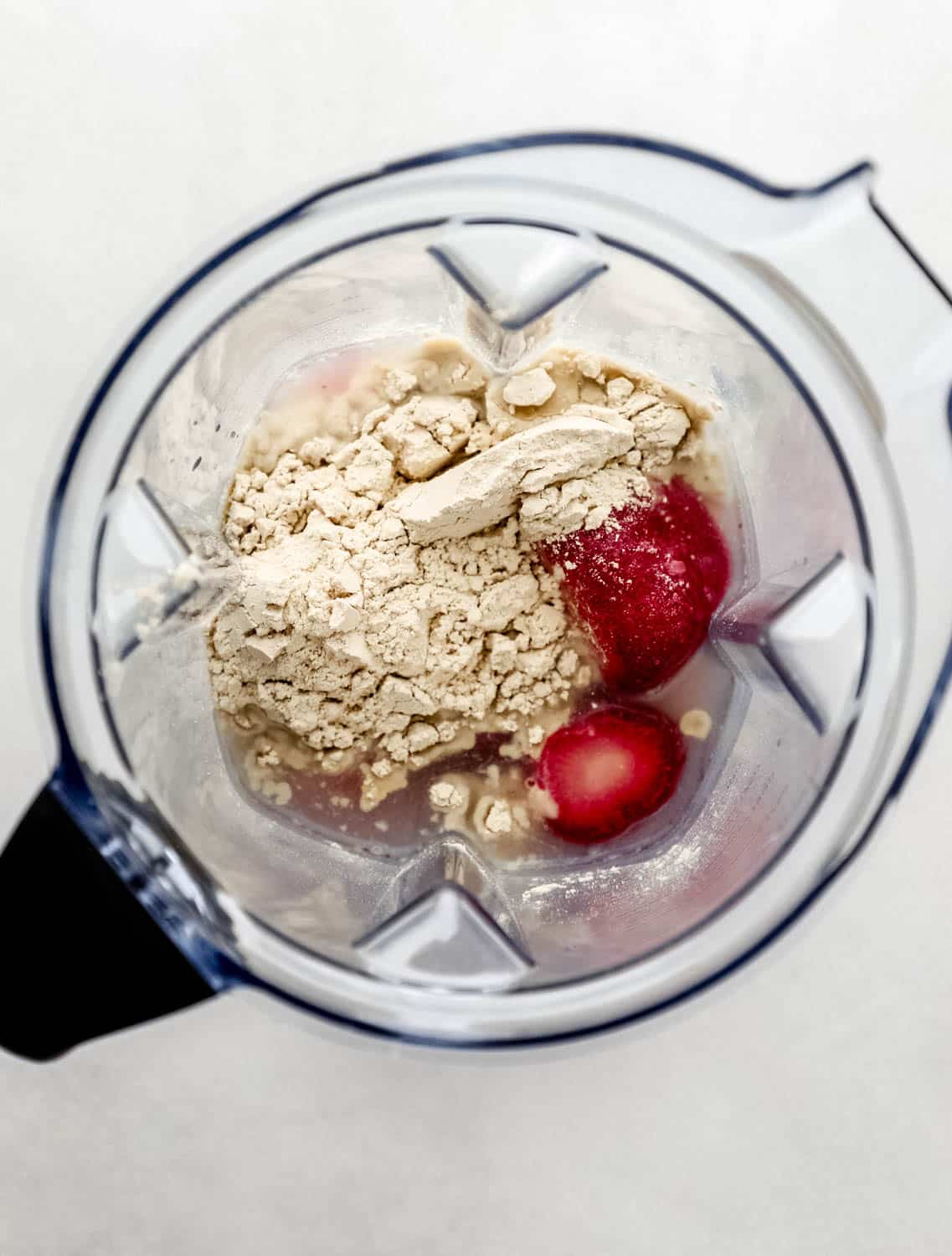 Overhead view of blender pitcher with smoothie ingredients in it. 