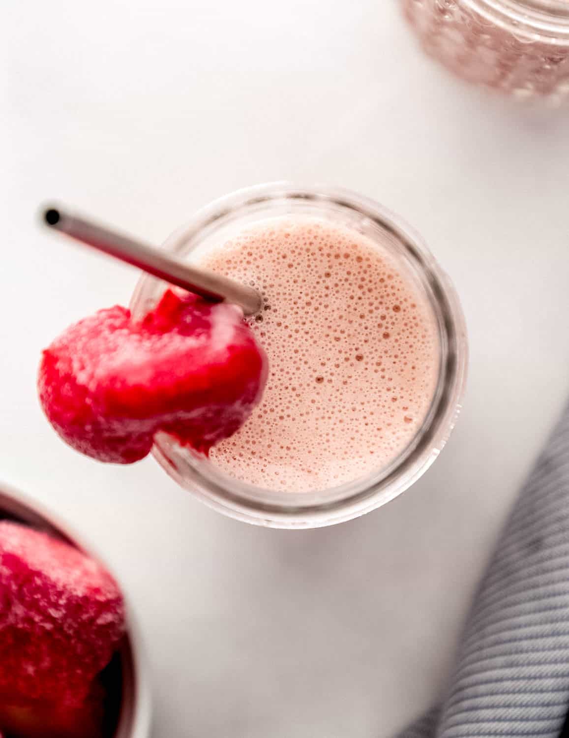 Overhead view of smoothie in glass with straw in it. 