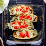 Overhead view of tacos in square glass baking dish.