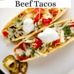 Overhead view of two finished tacos on white plate pin with text overlay.