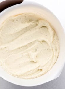 Overhead view of mashed potatoes in large white mixing bowl.
