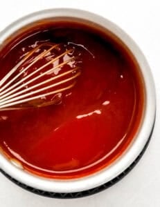 Sauce ingredients being whisk together in mixing bowl.