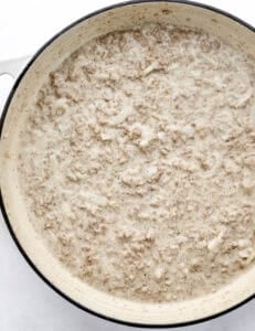 Finished hamburger gravy in large white braiser pan.