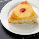 Close up side view of single piece of cake on white plate.