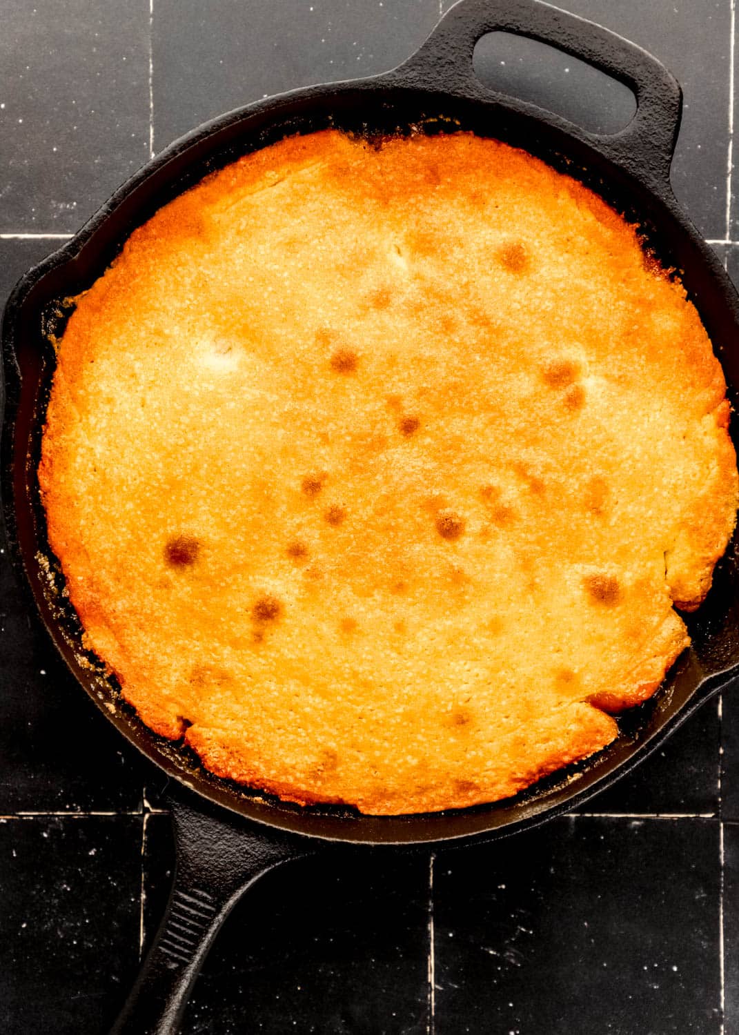 Overhead view of baked cake in cast iron skillet after it has been removed from the oven. 