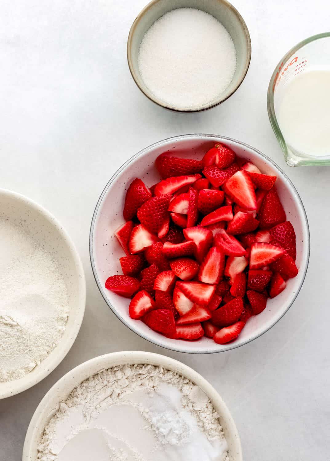 Overhead view of ingredients needed to make shortcake in separate bowls.