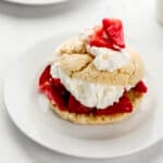 Close up side view of shortcake on white plate with another in the background.