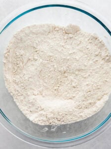 Overhead view of dry ingredients in a glass mixing bowl.