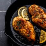 Close up front view of cooked chicken in cast iron skillet.