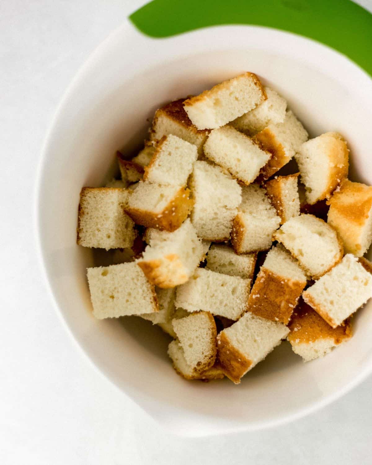 Cubed pound cake in large white bowl. 