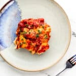 Overhead view of single serving of casserole on plate by a fork.