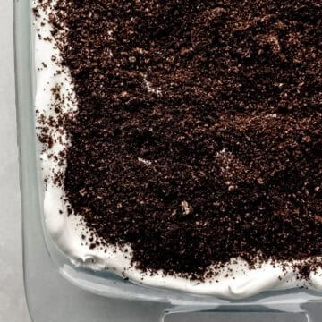 Close up overhead view of finished oreo delight in glass dish on grey surface.