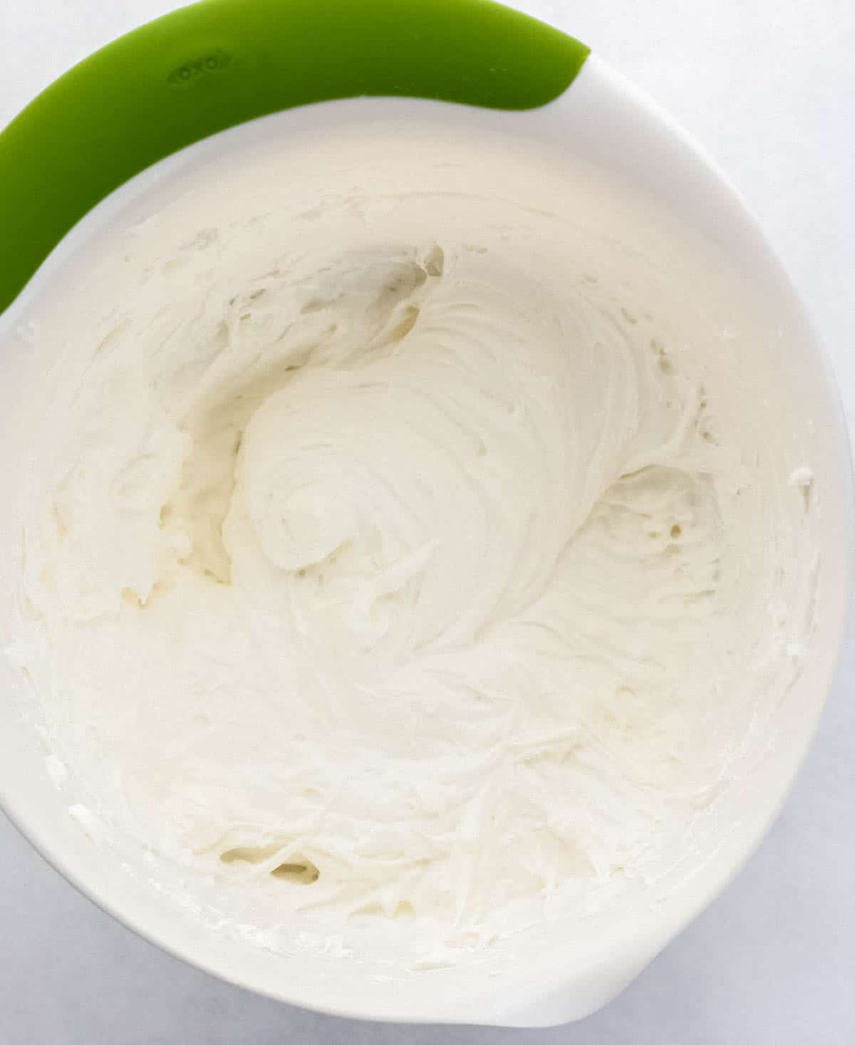 Creamed cheese and powdered sugar combined in large white mixing bowl. 