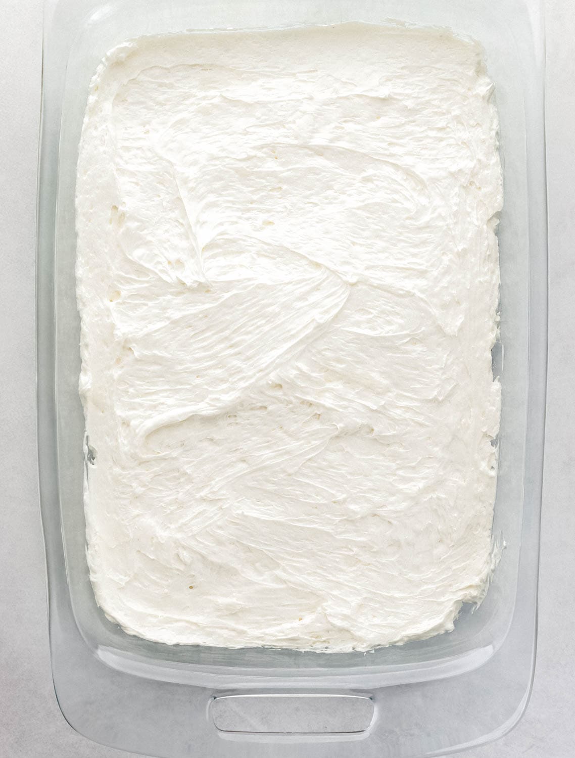 Cream cheese layer added to the top of the crust in the glass baking dish. 