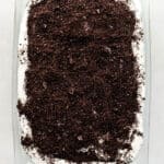 Overhead view of finished oreo delight topped with crushed cookied in rectangle glass dish.