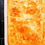 Overhead view of baked sausage casserole in rectangle white baking dish.
