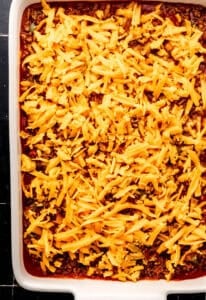 Beef mixture and shredded cheese added on top of the baked cornbread.