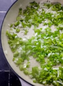 Close up view of onion and pepper in large braiser.