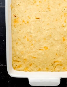 Cooked cornbread in white baking dish.