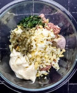 Tuna salad ingredients in large glass mixing bowl.