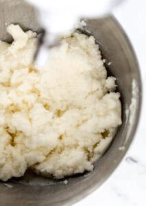 Close up view of butter, shortening, and sugar, combined in stand mixer.