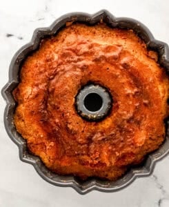 Overhead view of freshly baked pound cake in bundt pan on marble surface.