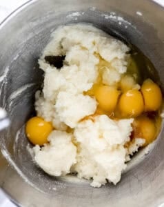 Eggs added to other cake ingredients in stand mixer bowl.