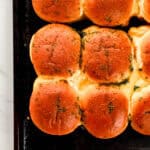 Overhead view of baked sliders on sheet pan.