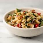 Close up side view of serving of pasta in white bowl.