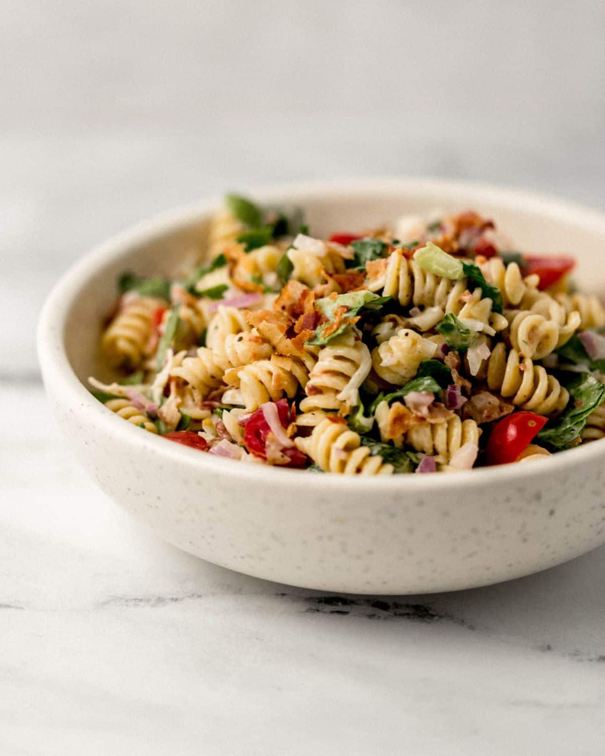 Close up side view of serving of pasta in white bowl. 