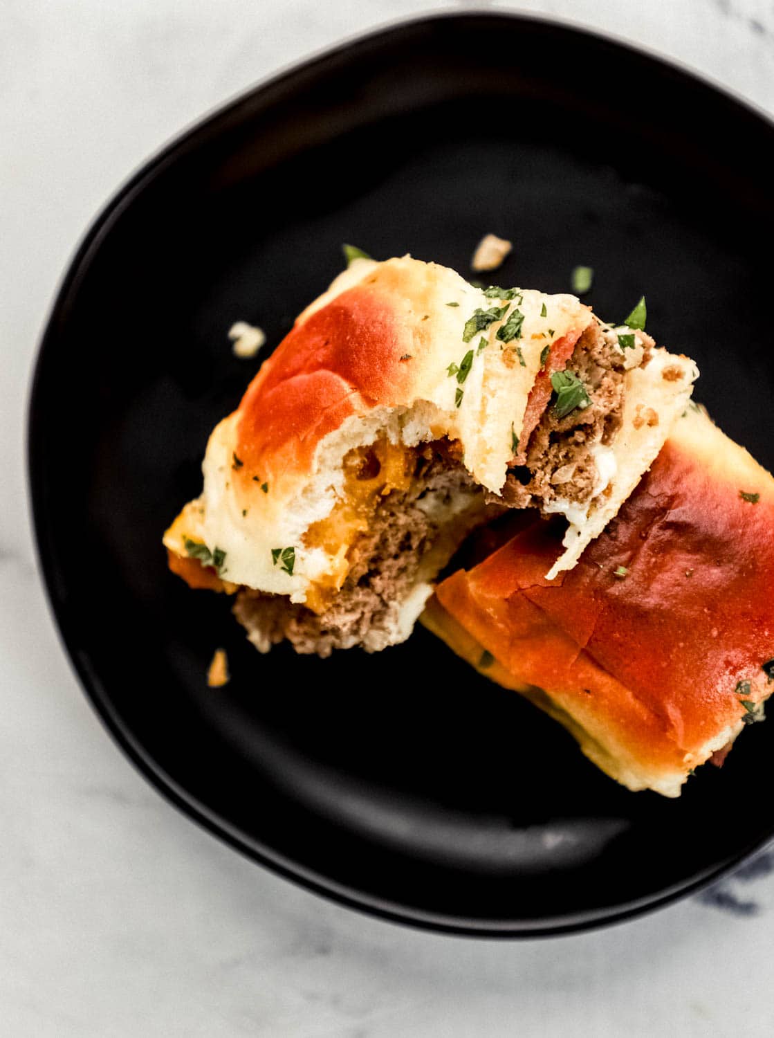 Two sliders on black plate with one of the sliders bit into. 