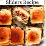Close up overhead view of finished sliders in parchment lined baking dish on pin with text overlay.