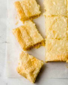 Overhead view of cut squares on parchment paper on top of marble surface.