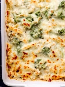 Close up overhead view of baked alfredo pasta in white casserole dish.