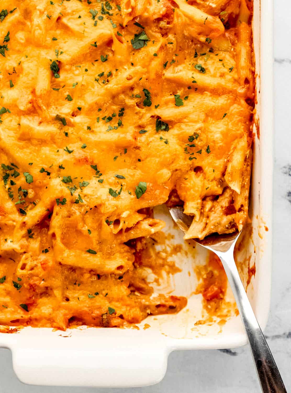 Overhead view of pasta in casserole dish with serving spoon in it.