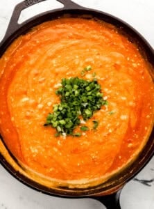 Overhead view of sauce ingredients combined in cast iron skillet.