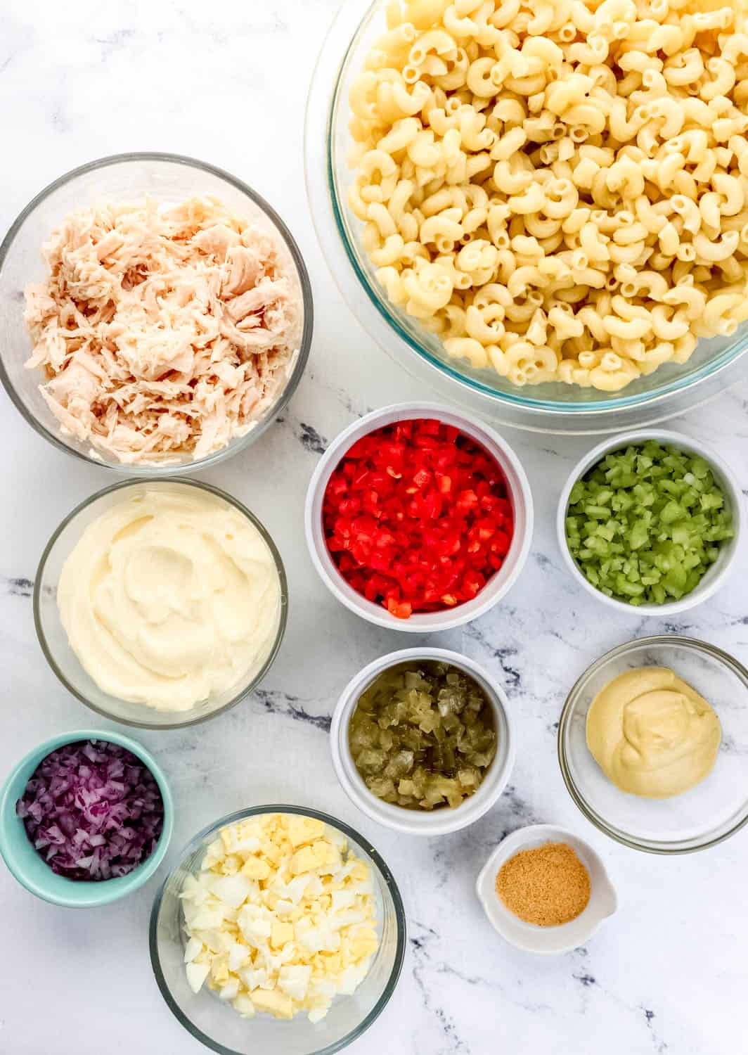 Overhead view of ingredients in separate bowls on marble surface.
